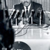 Dr. King speaking into microphones.